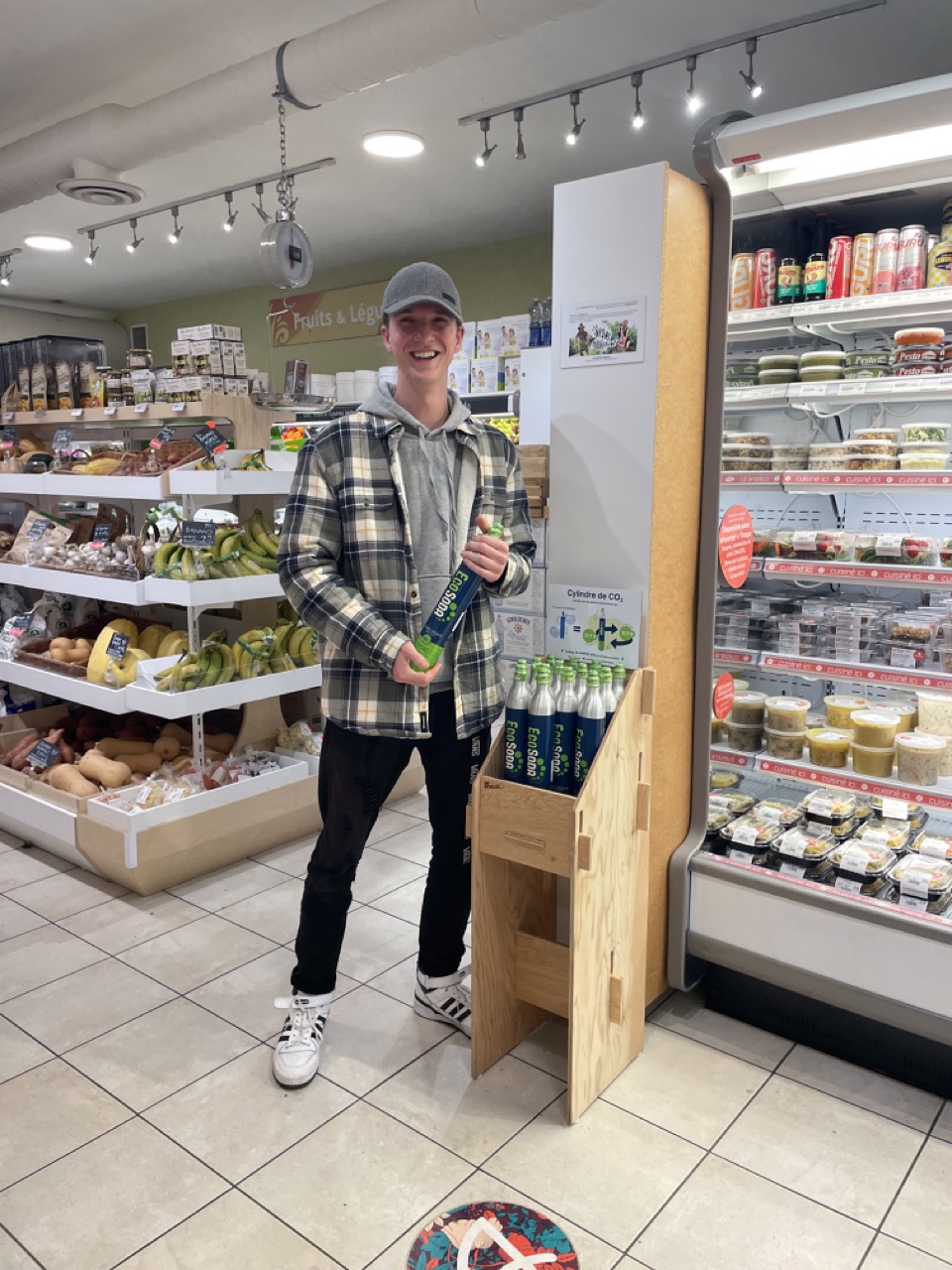 Employer du magasin posant avec la bouteille